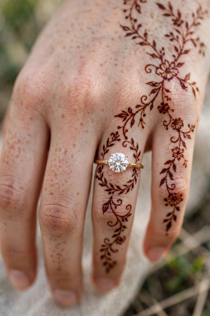 Engagement henna with delicate vines framing the engagement ring